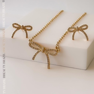 Detalhes do produto Brinco Lacinho cravejado com zircônias cristais, em ouro.
