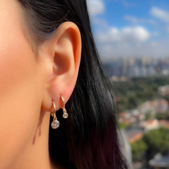Detalhes do produto Brinco argola articulada com uma zirconia P, em ouro