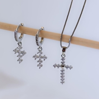 Detalhes do produto Brinco argolinha com cravejamento e cruz de cristais, em ródio.