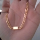 Choker com uma plaquinha lisa, em ouro